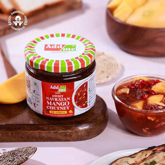 Jar of Add Me Sweet Navratan Mango Chutney on a wooden board with food items in the background, mango chutney