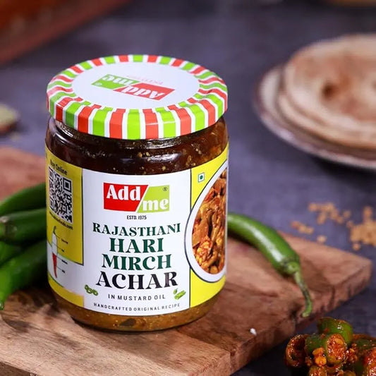 Add Me Foods: Jar of Add Me Rajasthani Hari Mirch Achar on a wooden board with green chilies.