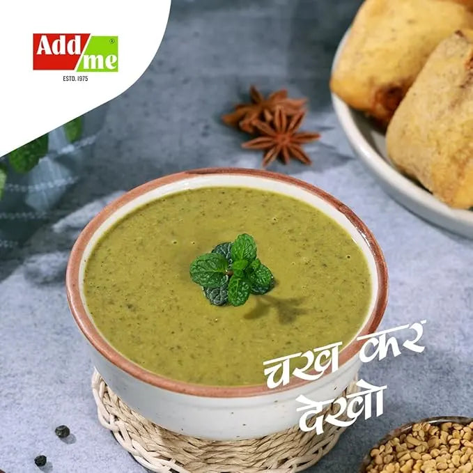 Bowl of green soup with a garnish, placed on a textured surface with 'Add Me' branding.