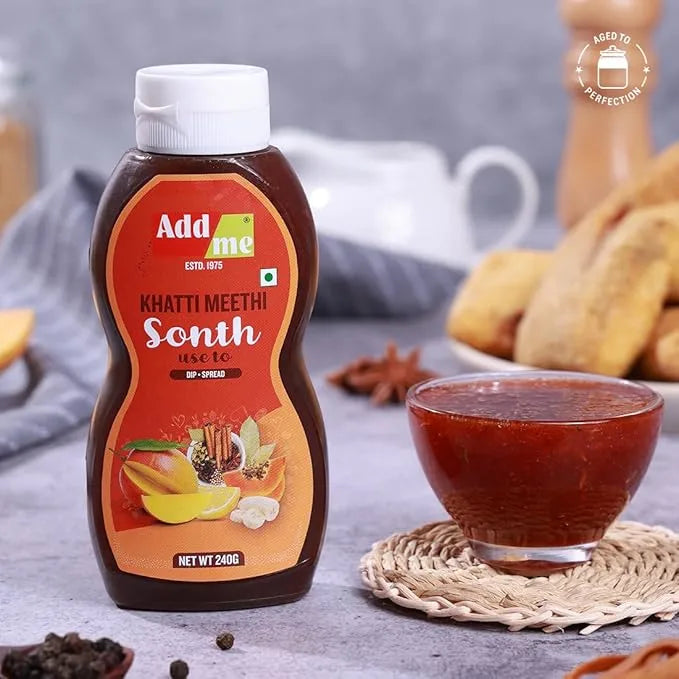 Bottle of Add Me Khatti Meethi Sonth with a bowl of sonth on a table.