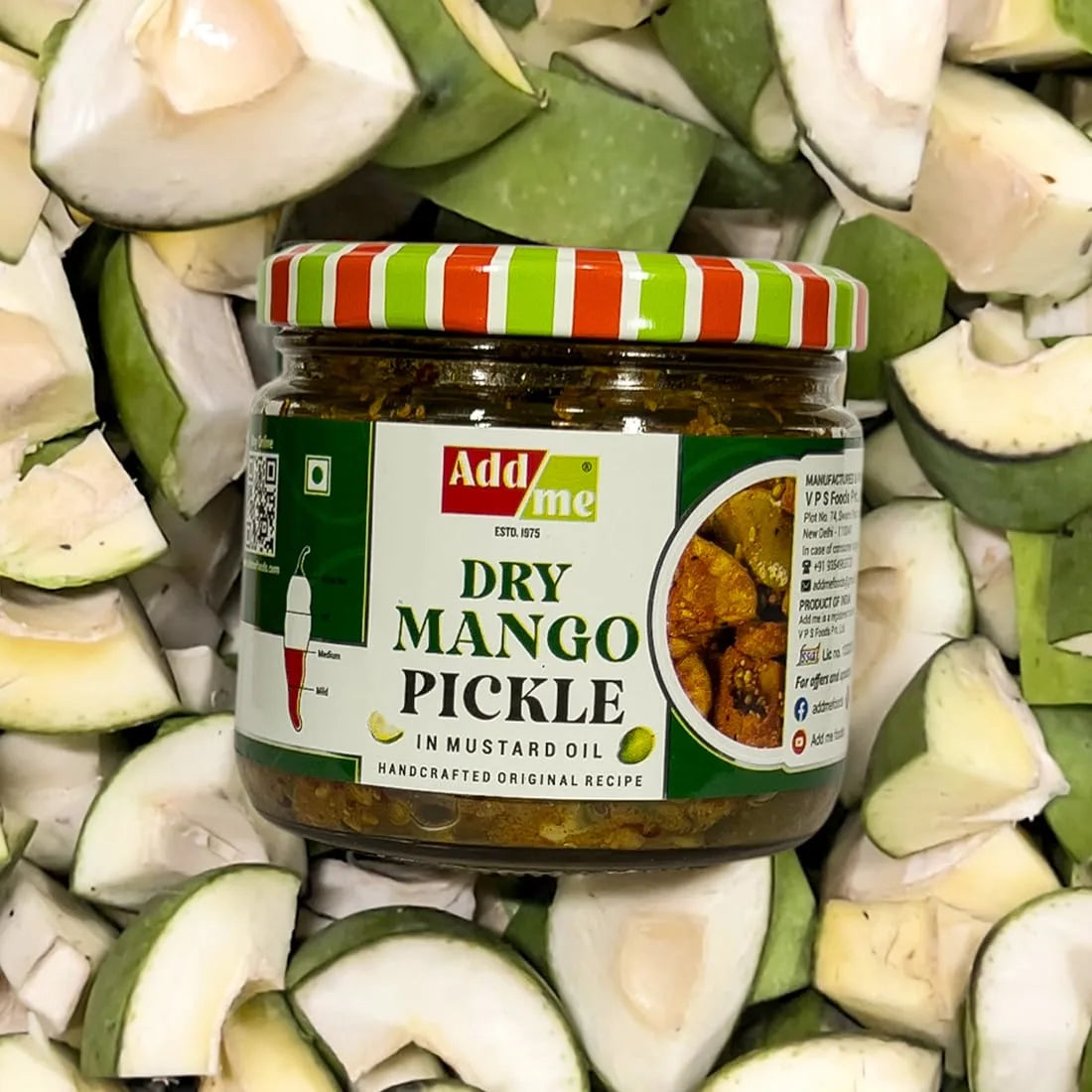 Jar of Add Me Dry Mango Pickle surrounded by green mango slices