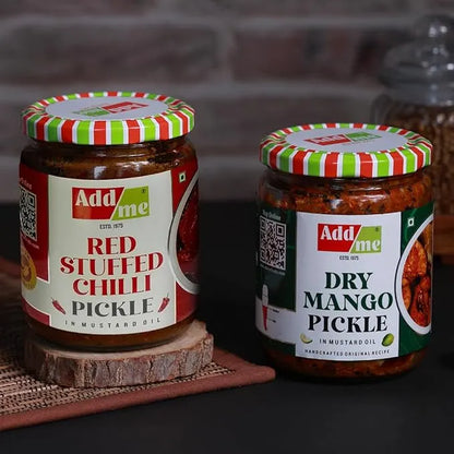 Two jars of pickles with colorful lids on a wooden surface. mango pickle, chilli pickle