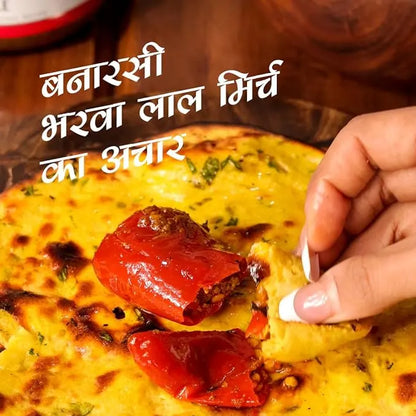 Person dipping a piece of food into a bowl with text overlay. mango pickle, chilli pickle