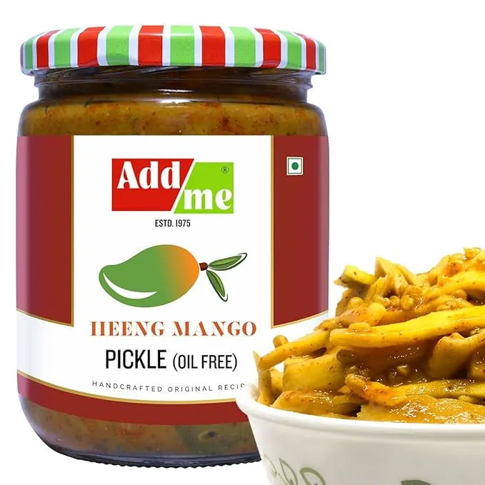 Jar of Add Me Heeng Mango Pickle with a bowl of pickles on a white background
