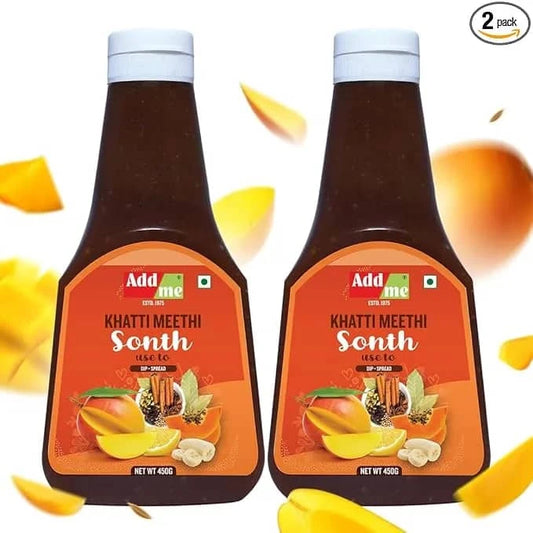 Two bottles of Add Me Khatti Meethi Sonth with mango slices on a white background. sonth chutney
