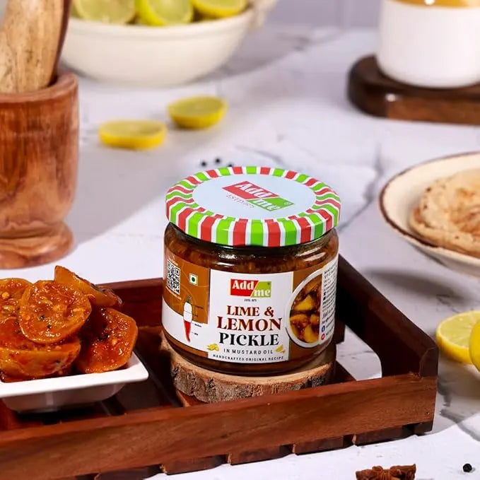 Jar of lime and lemon pickle on a wooden tray with snacks and lemons in the background