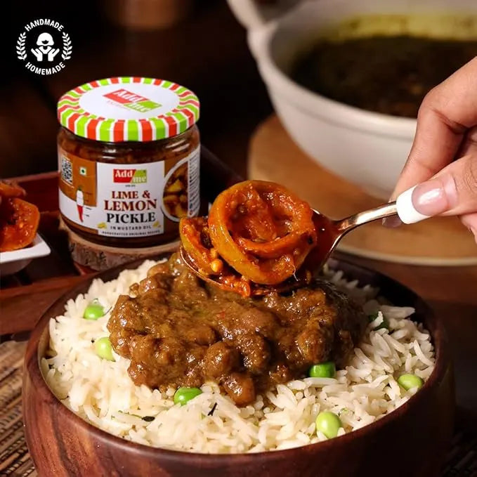 Bowl of curry with rice and pickles, featuring a jar of lime and lemon pickle.