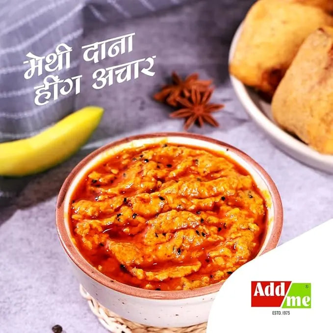 Bowl of red chutney with banana, spices, and bread on a gray surface with 'Add Me' branding.