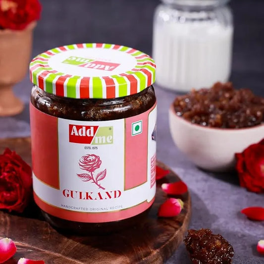 Add Me Foods: Jar of Add Me Gulab on a wooden board with flowers and gulab in the background