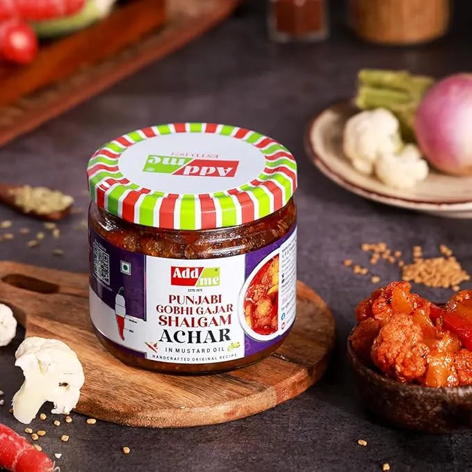 Jar of Punjabi Gobhi Gajar Shalgam Achar on a wooden board with ingredients in the background