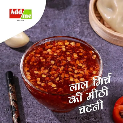 Add Me Foods: Glass bowl of red chili garlic chutney with Addme logo on a dark surface