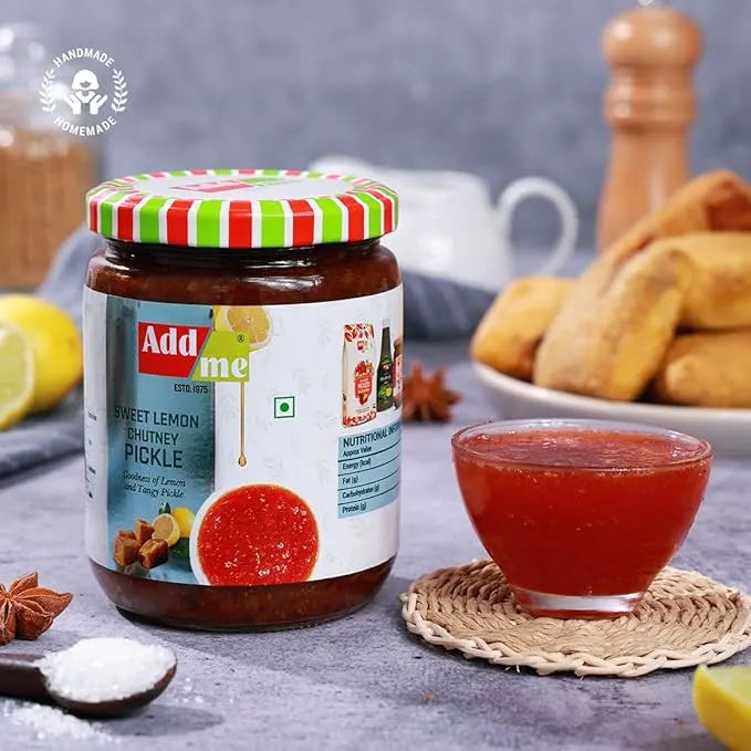 Jar of Add Me sweet lemon chutney pickle with a small bowl of red chutney on a table.