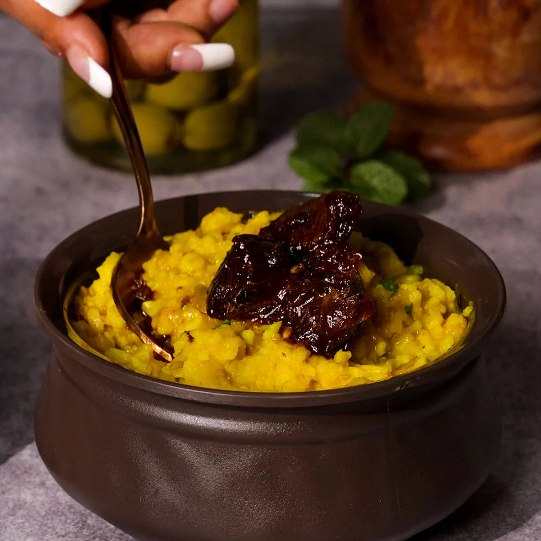 Jar of Add me Lemon Pickle with rice(Poha) on a wooden surface with ingredients in the background, lemon pickle